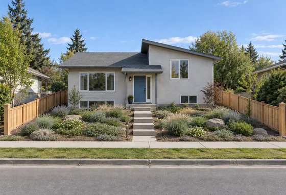 A sloped split-level front garden planted with low groundcover and ornamental grasses around the retained concrete steps.